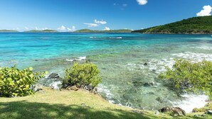 A clear coastal view with turquoise water, green vegetation, and distant hills. - Suite St. John at Gallows Point Resort (St. John)