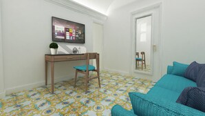 Una habitación con escritorio, silla y cama con almohadas azul turquesa y azul.
