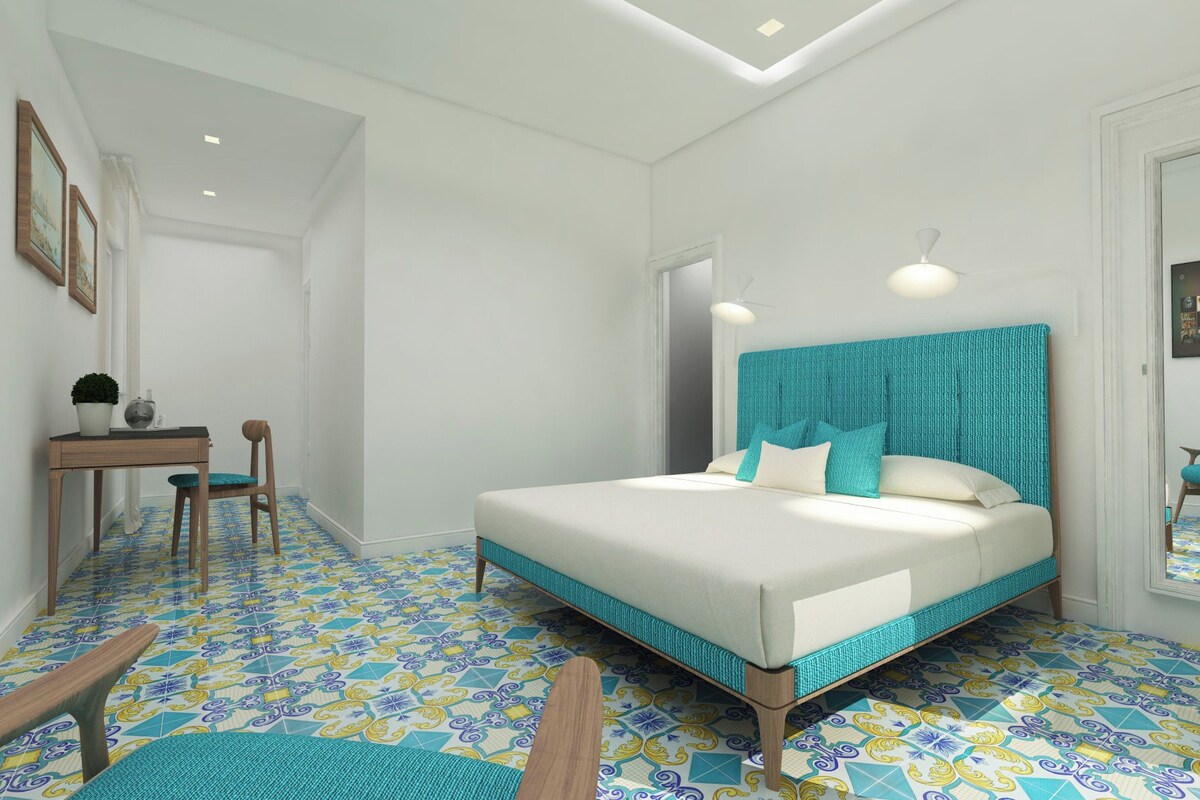 A bedroom with a bed, a desk, and a chair.