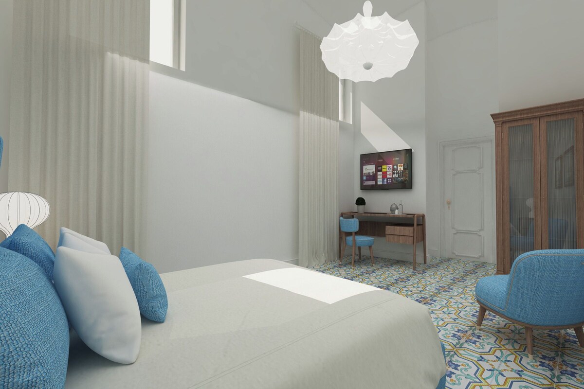 A bedroom with a bed, a desk, a chair, and a wardrobe.