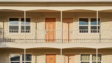 A two-story building with numbered doors, balconies, and windows.