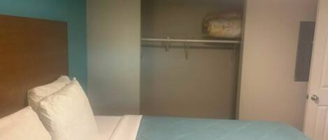 Un dormitorio con cama, armario y puerta.