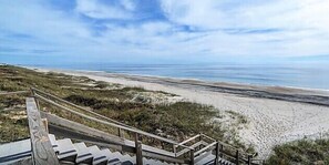 A beach with a wooden staircase leading down to the shore. - The Beacon (Salter Path)