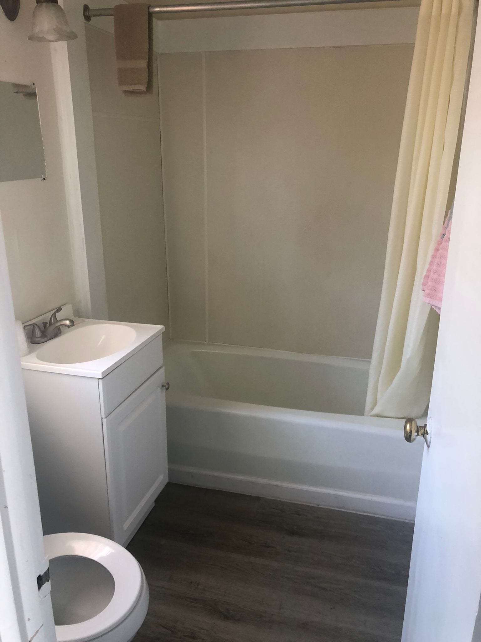 Un bagno con lavandino, water e vasca da bagno bianchi.
