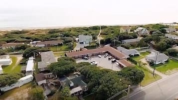 Vista aérea de uma área residencial com casas, um estacionamento e uma rua.