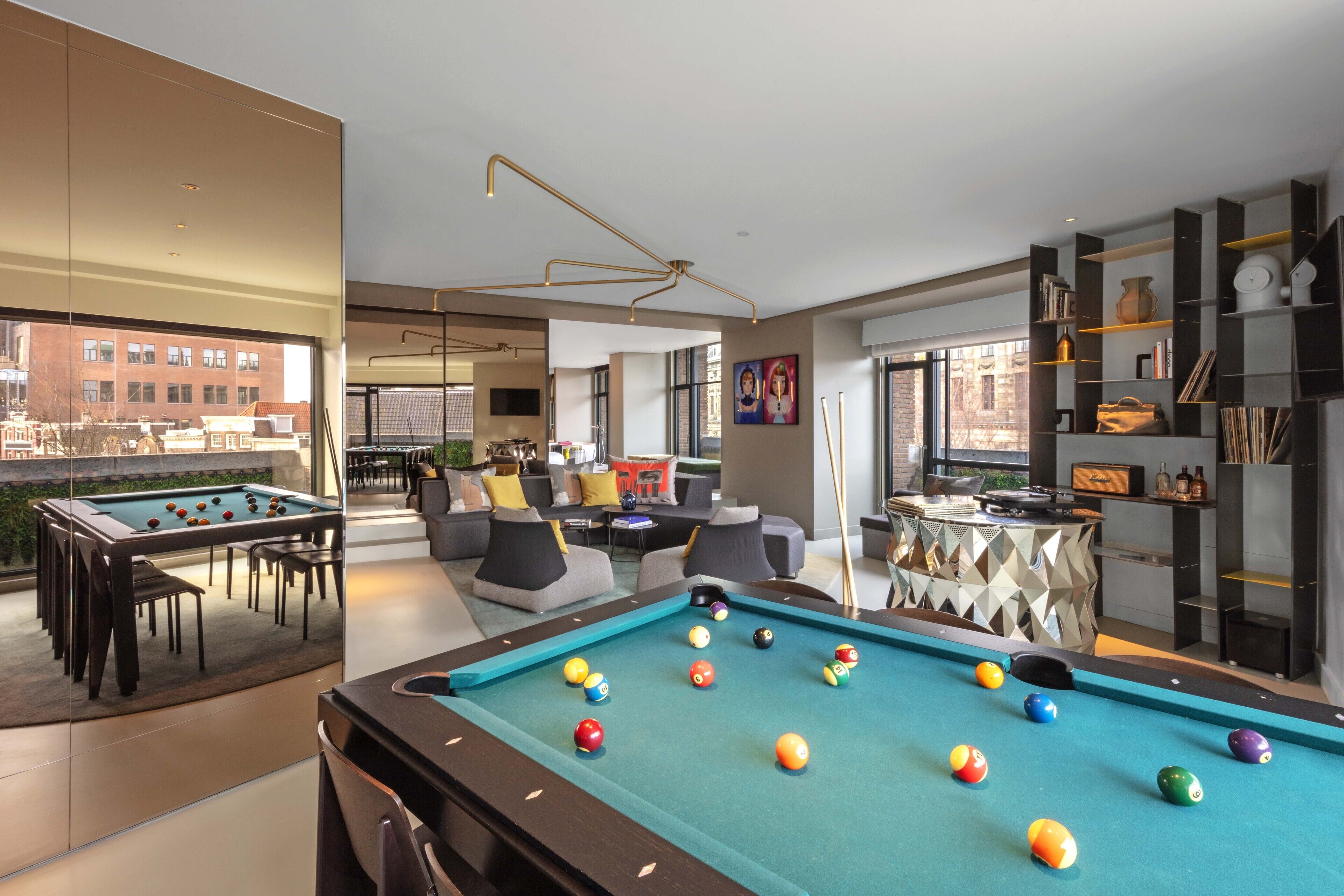 Een pooltafel met ballen, een bank en een bar in een modern interieur.