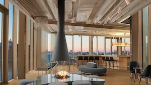 Ein stilvoller Lounge-Bereich mit Glastisch, Sitzgelegenheiten und Kamin.