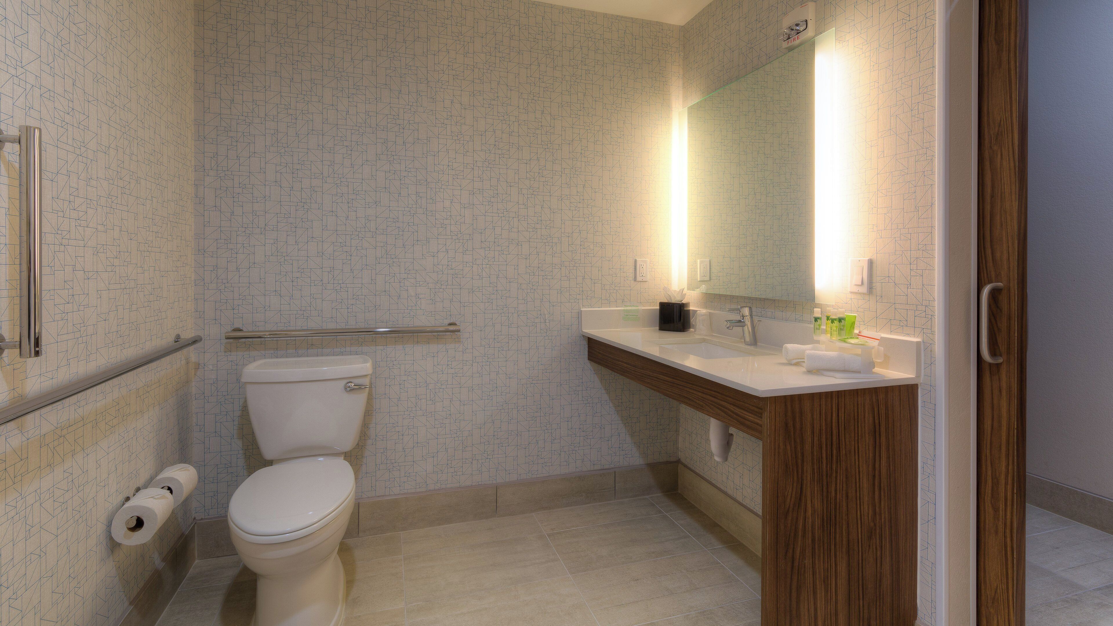 Ein Badezimmer mit Toilette, Waschbecken, Spiegel und Handtuchhalter.