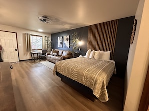 A bedroom with a bed, a desk, and a couch. - The Roscoe (Coshocton)