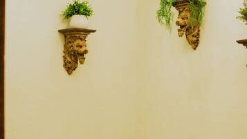 A bathroom with a white sink, a bathtub, and two wall-mounted shelves with plants.