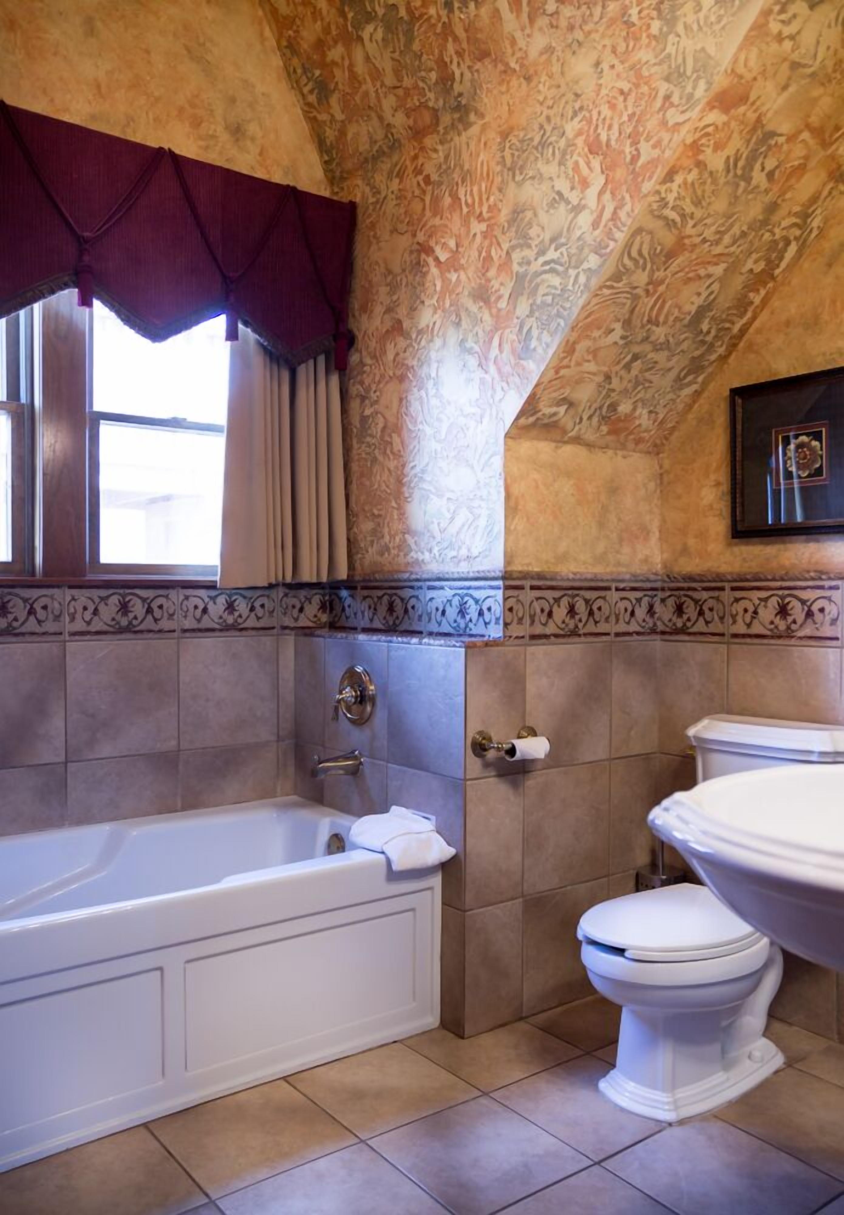 A bathroom with a bathtub, toilet, and vanity.
