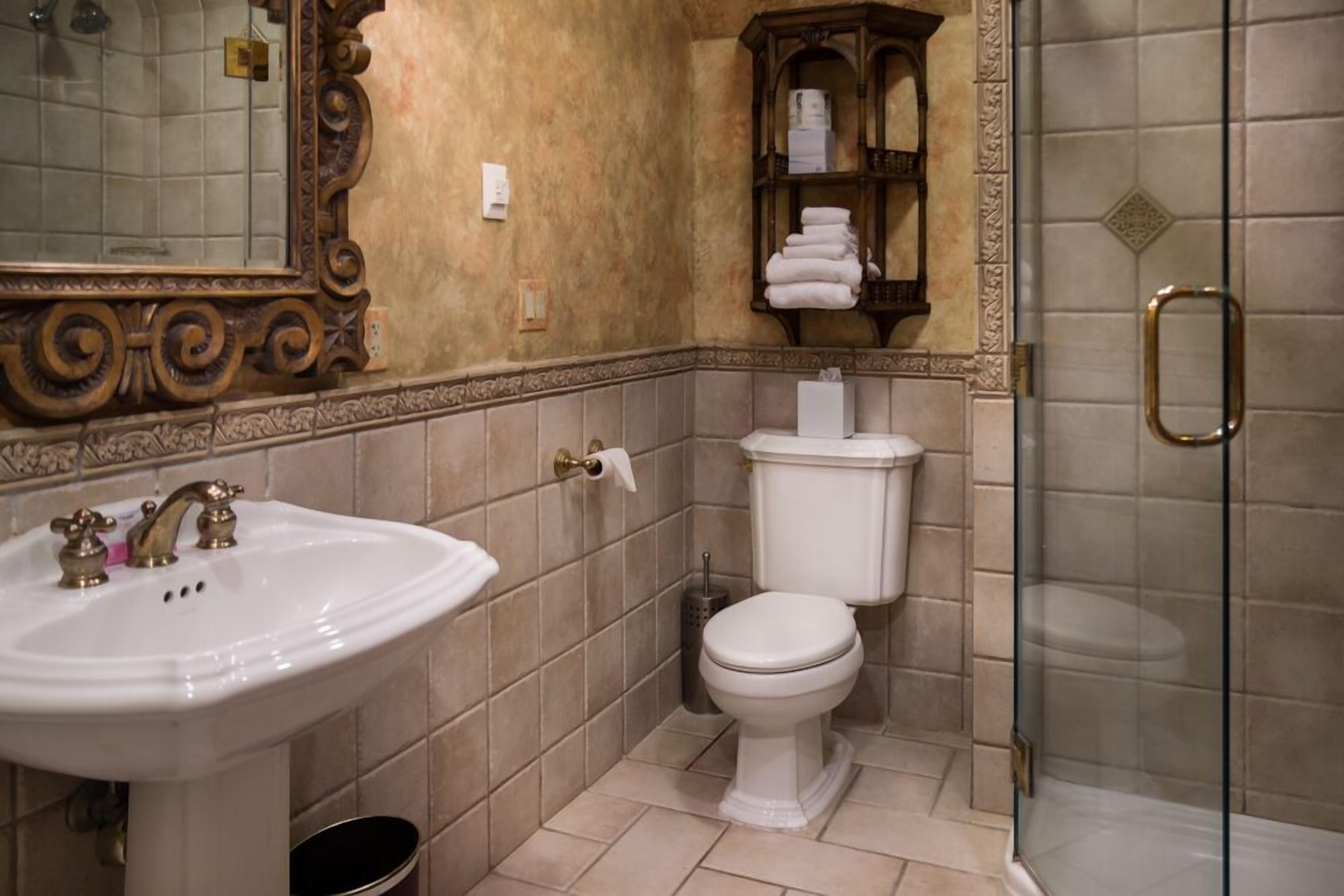 A bathroom with a white sink, a toilet, and a glass shower enclosure.