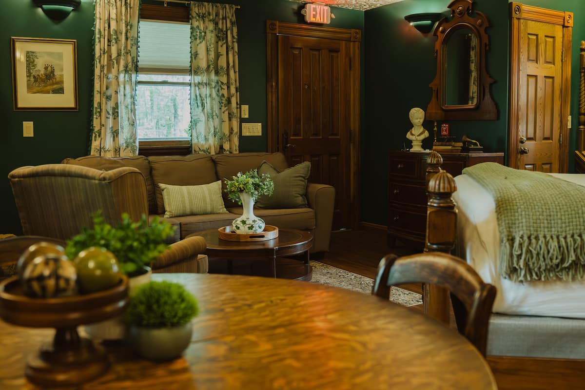 A cozy living room with a sofa, a dining table, and a wooden cabinet.