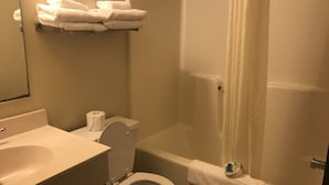 Un baño con inodoro, lavabo y zona de ducha.