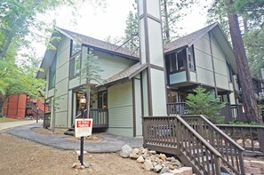 A two-story building with a porch and a staircase leading to the entrance. A 'No Public Parking' sign is visible in front.