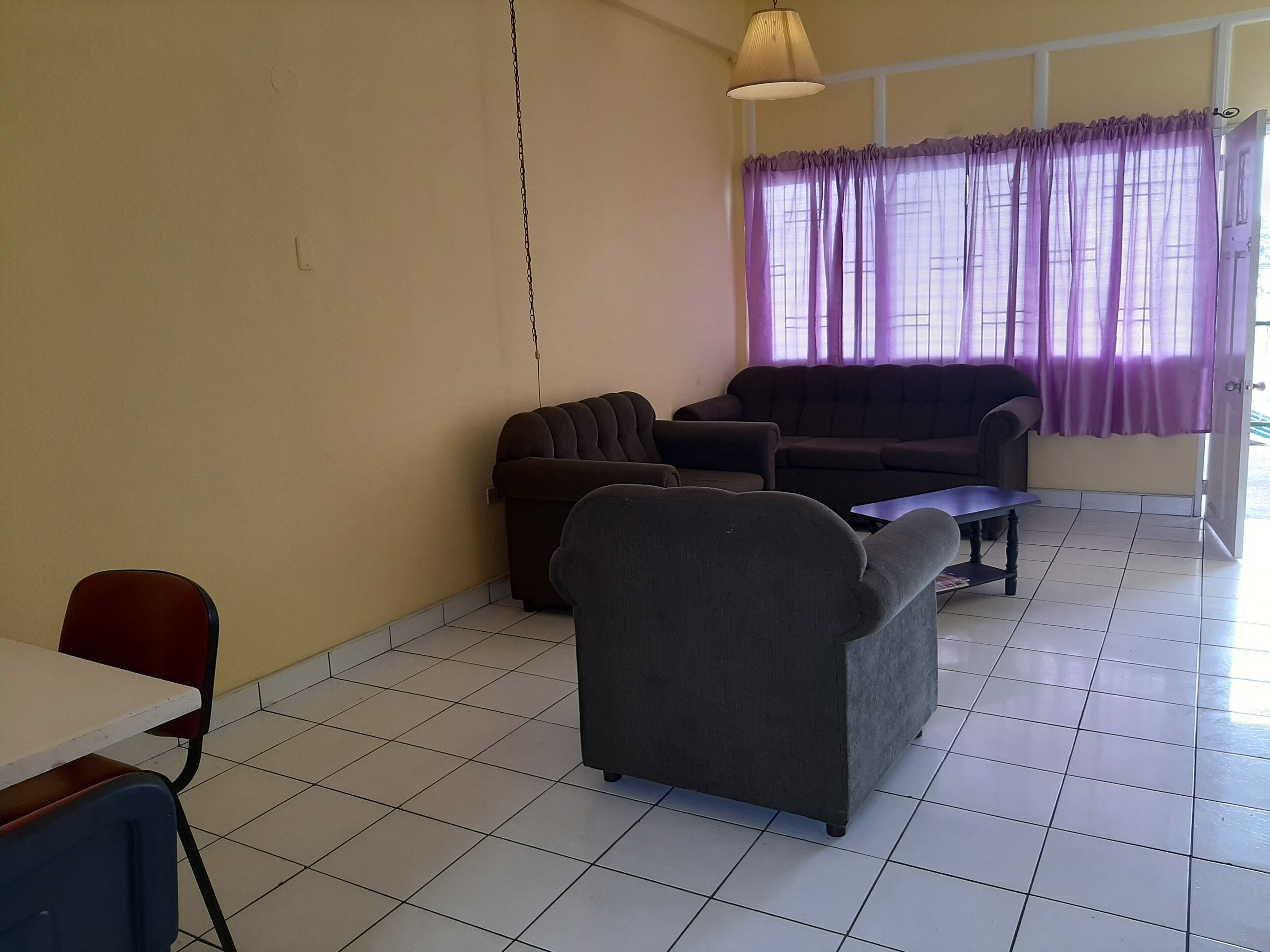 Una sala de estar con un sofá, un sillón y una mesita.