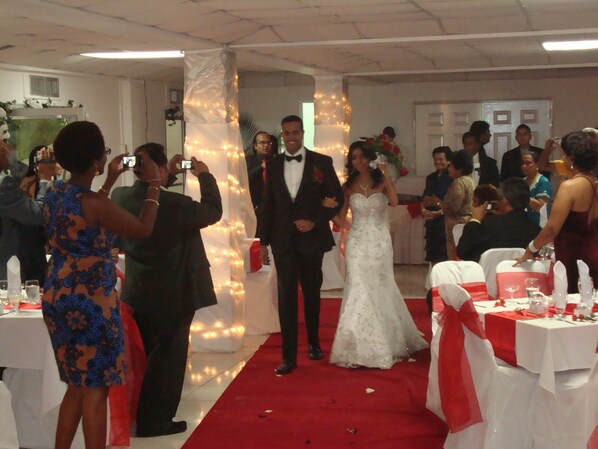 A wedding ceremony with guests and a bride in a white dress. - Royal Palm Suite Hotel (Port of Spain)