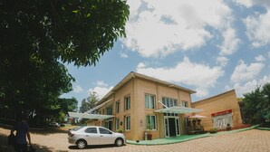 A building with a brick facade, a car parked in front, and a person walking. - La Dolce Villa (Avare)