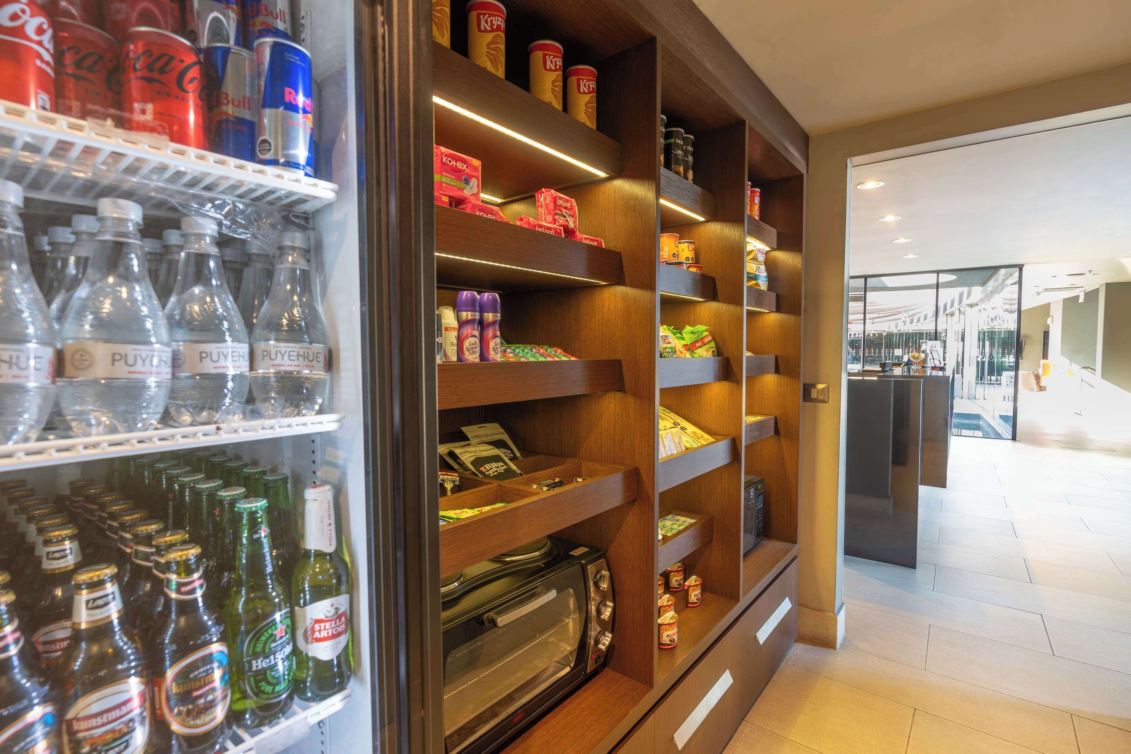 A well-organized beverage refrigerator stocked with various drinks, a microwave, and a toaster.