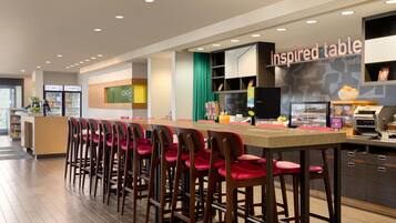A modern bar area with a long counter and multiple stools.
