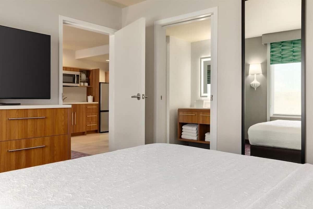 Une chambre d’hôtel comprenant un lit, une télévision, un coin cuisine et une salle de bain.