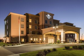 A hotel with a stone facade, a well-lit entrance, and a sign for Homewood Suites. - Homewood Suites by Hilton Frederick (Frederick)