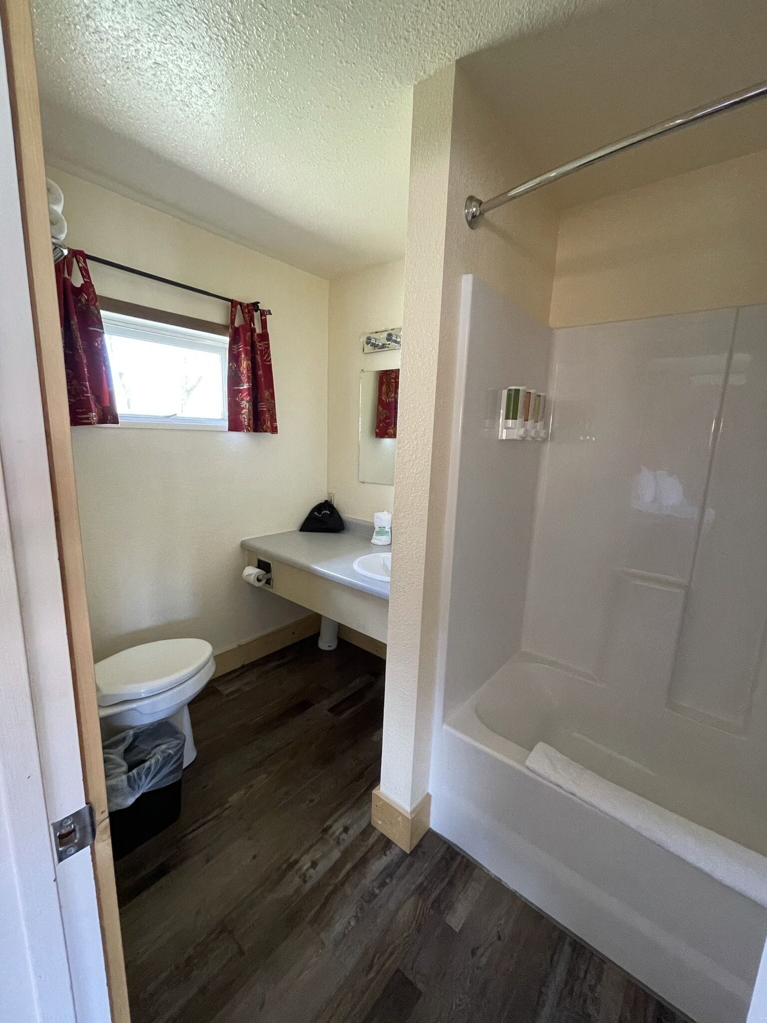 Un baño con inodoro, lavabo, espejo y ducha.