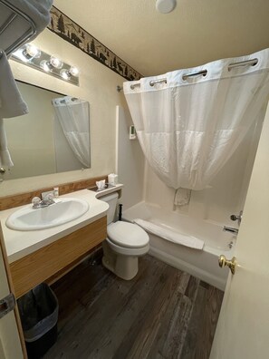 A bathroom with a sink, toilet, and bathtub.