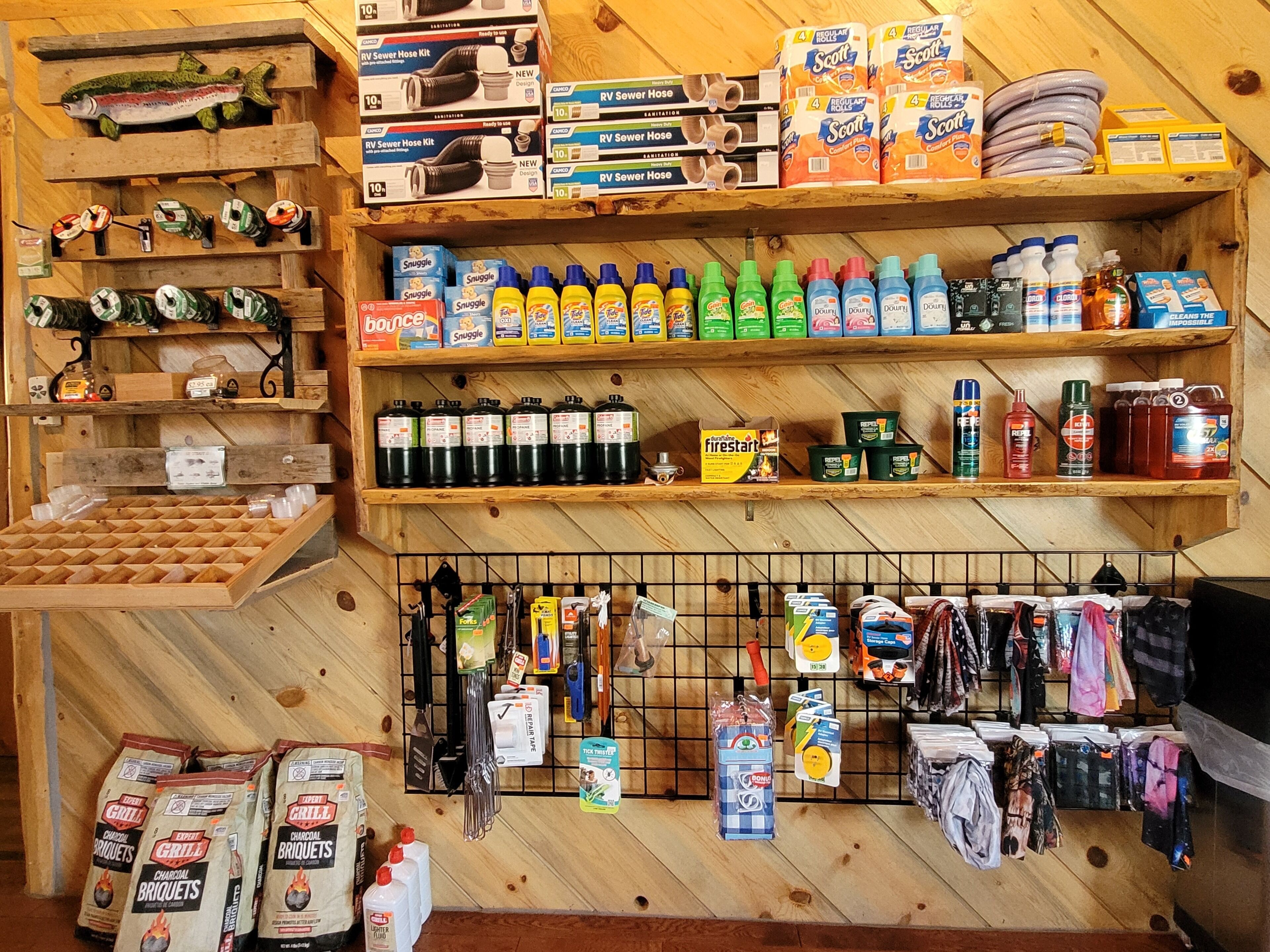 Una tienda con estantes llenos de mangueras para aguas residuales de vehículos recreativos, productos de limpieza y artículos para barbacoa.