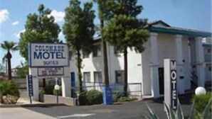 A motel with a sign reading "Colonae Motel Suites" and a gated entrance. - Colonade Motel (Mesa)