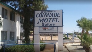 A motel sign for O'CaIrns ColonaDe Motel Suites advertising special rates and free kitchenettes. - Colonade Motel (Mesa)
