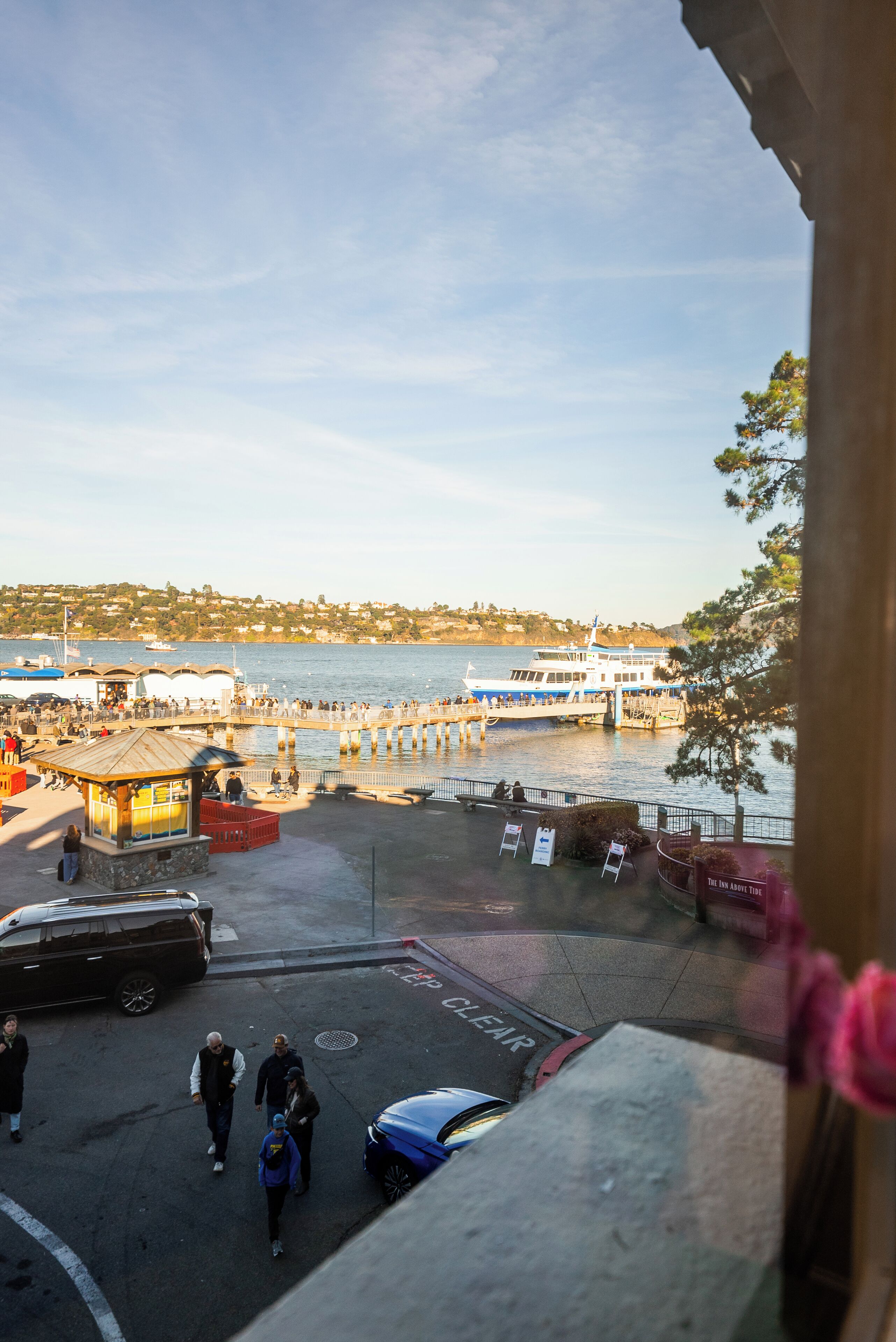 A waterfront view with a pier, boats, and a small building.