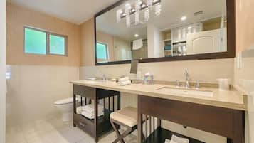 A modern bathroom with a double sink vanity, a large mirror, and a chandelier.