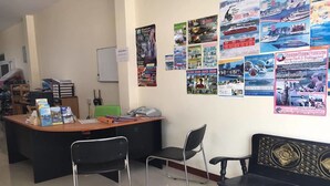 A reception area with a desk, chairs, and a bench. There are various posters on the wall. - Lanta Sun Smile Place (Ko Lanta)