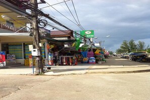 A small shop with an ATM sign, various colorful items on display, and a signboard advertising a time table. - Lanta Sun Smile Place (Ko Lanta)