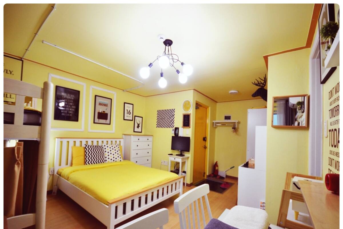 A room with a bed, a desk, a chair, a dresser, and a mirror.