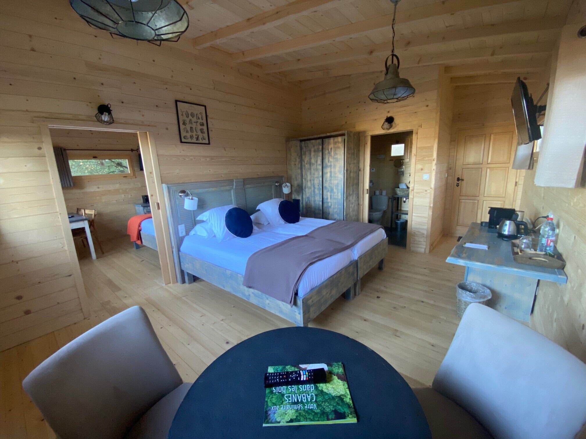 Una habitación acogedora tipo cabaña de madera, con cama, mesa y silla.