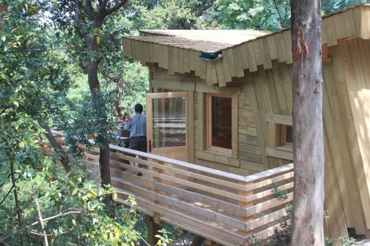 Eine Holzhütte mit einem Balkon, umgeben von Bäumen.