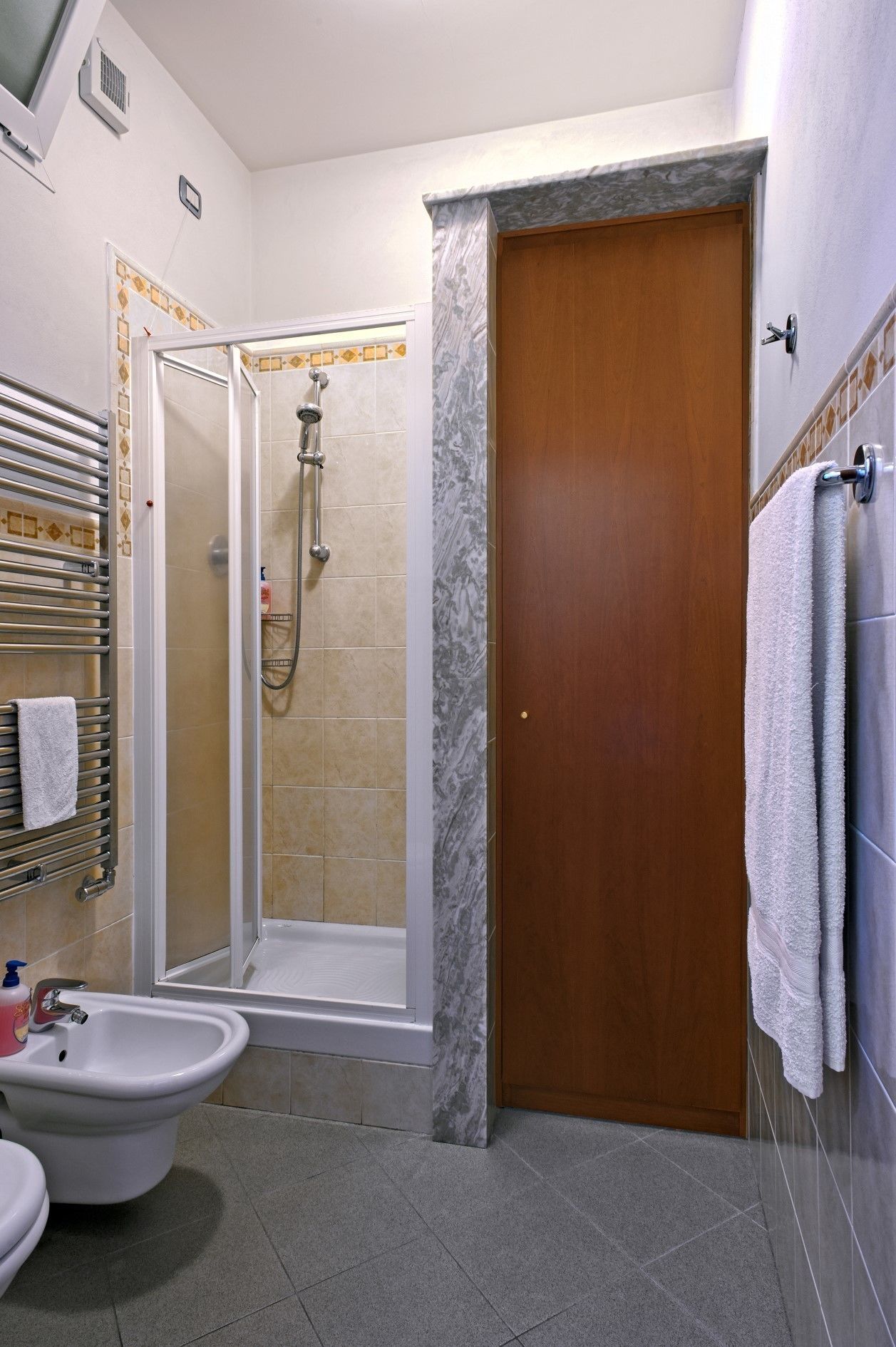 A bathroom with a shower, toilet, and sink.