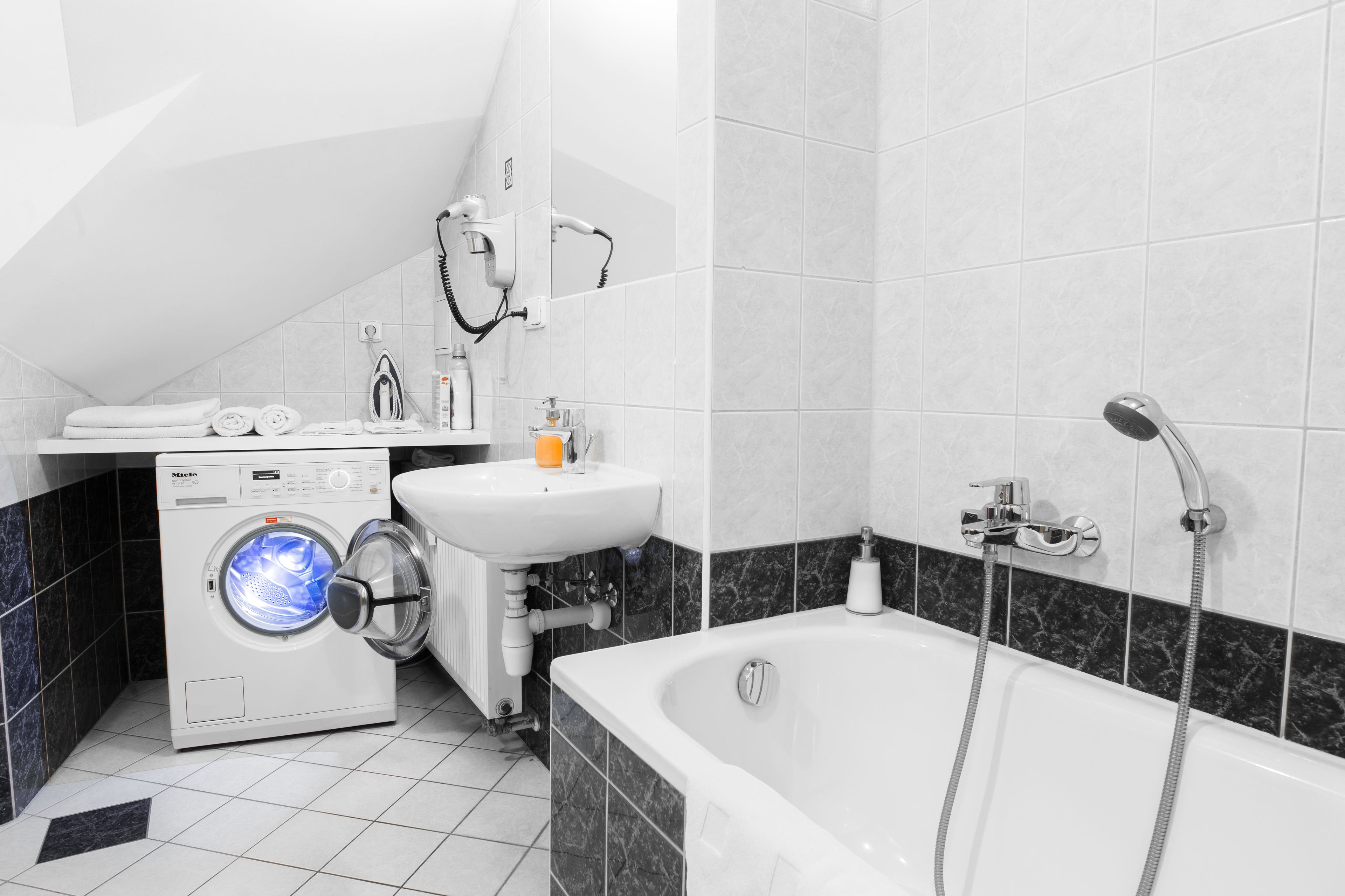 Un baño moderno con lavadora, lavamanos y bañera.