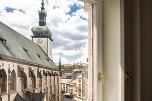 Vista de un edificio histórico con una torre de reloj e iglesia con arcos apuntados.