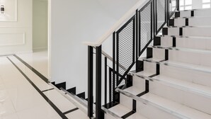A modern staircase with white steps and black railings, leading to an upper floor. - Ratchada Point Hotel (Bangkok)
