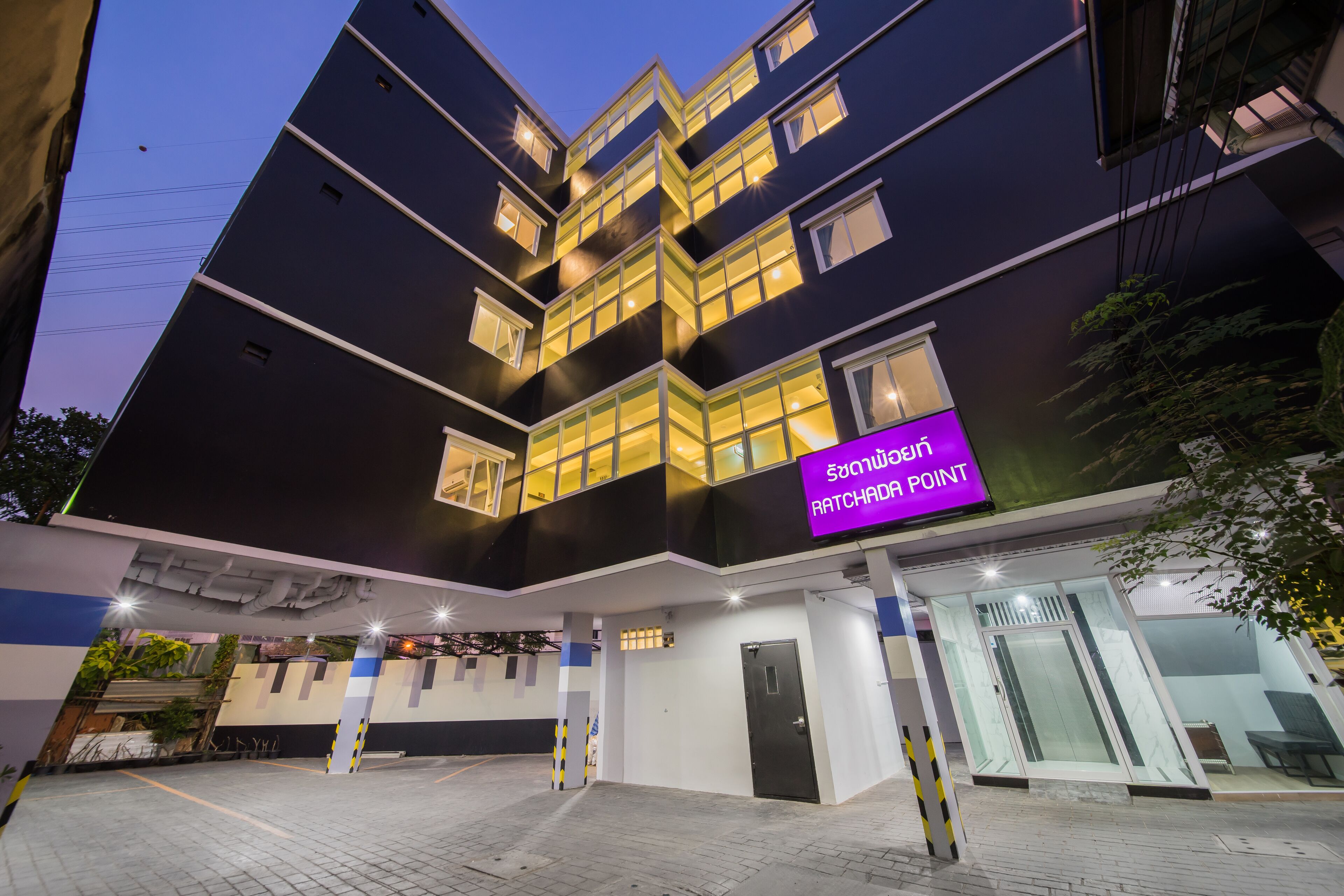 Un edificio moderno con un cartello all'ingresso che riporta la scritta "Ratchadaphon Point".