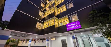 Un edificio moderno con un cartello all'ingresso che riporta la scritta "Ratchadaphon Point".