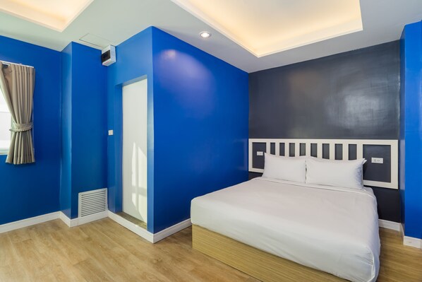 A modern bedroom with a large bed, a ceiling light, and a window with curtains.