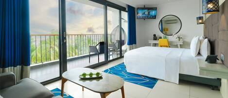 A hotel room with a large bed, a desk, a chair, a TV, and a balcony with a view.