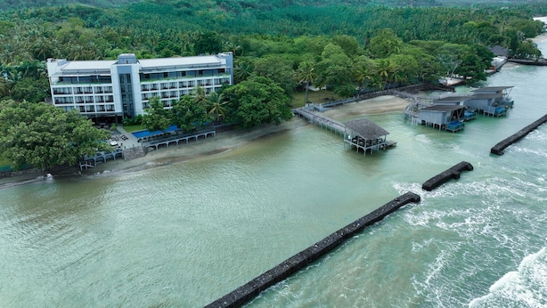 Un hôtel au design moderne, situé au bord d’une rivière, avec un quai et des structures flottantes.