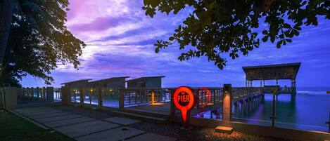 Un muelle con un cartel que dice "The Pier" al anochecer.