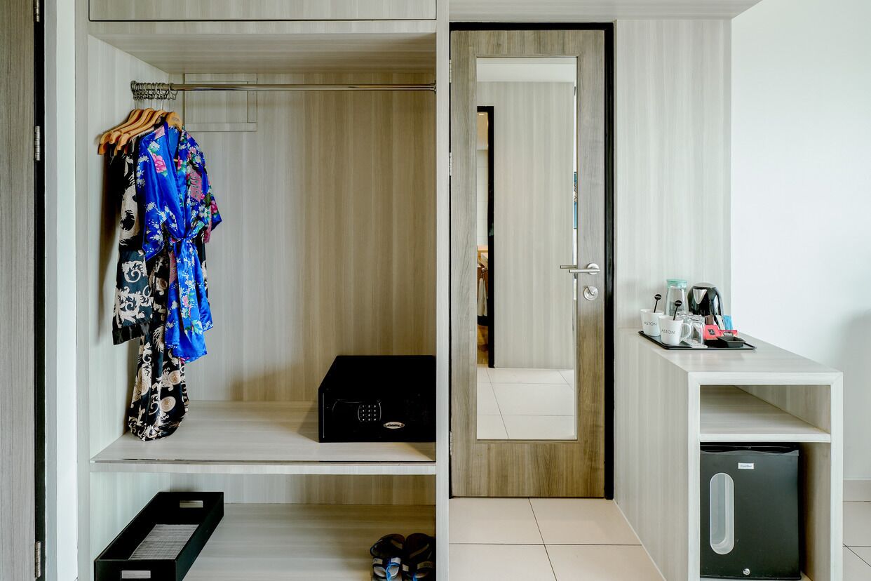 Una camera d'albergo con cabina armadio, angolo cottura e bagno.