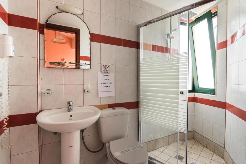 A bathroom with a sink, toilet, and shower.